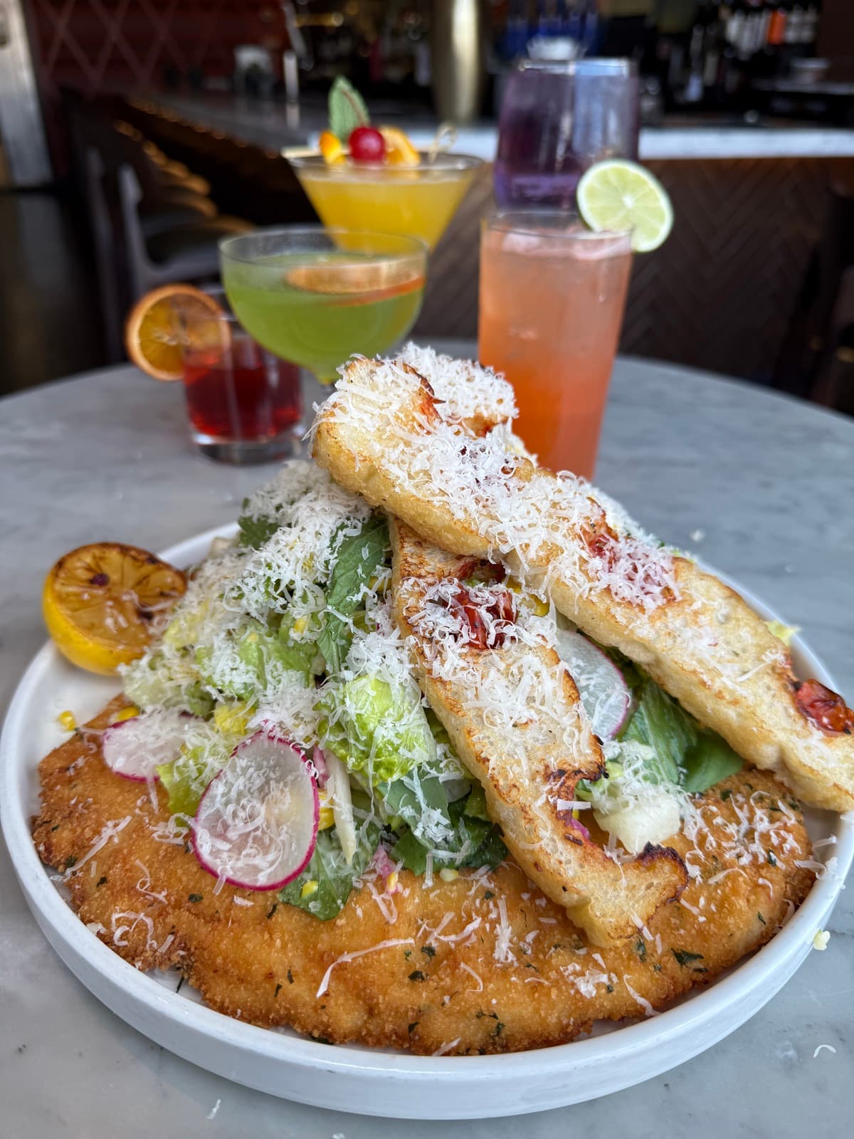 Chicken milanese with Caesar salad and craft cocktails